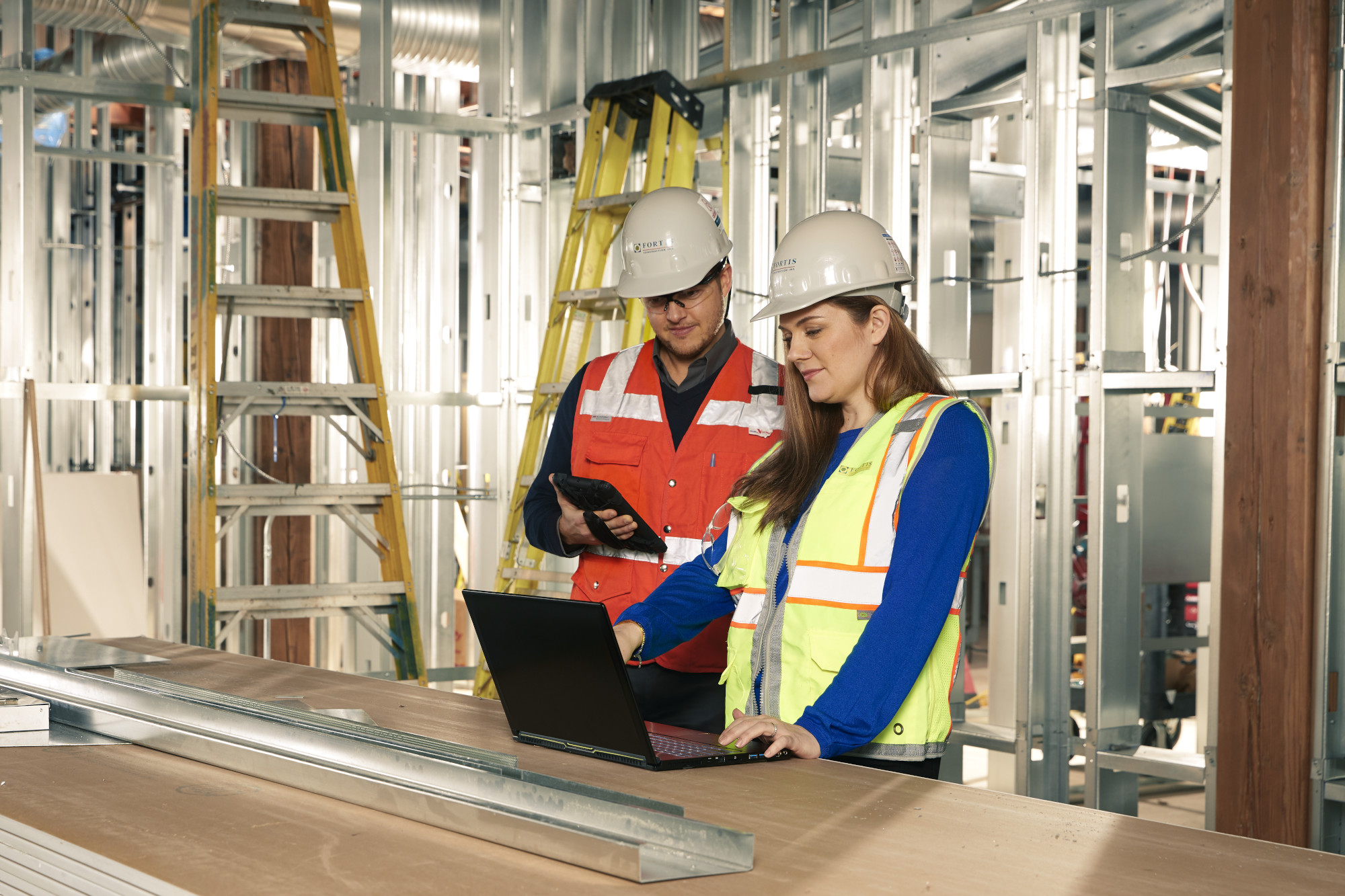 Colleagues with laptop at construction site