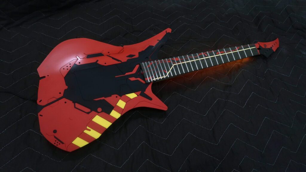 Red acrylic electric guitar with yellow acrylic inlay