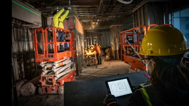 construction KPIs with construction worker on jobsite with technology (iPad)