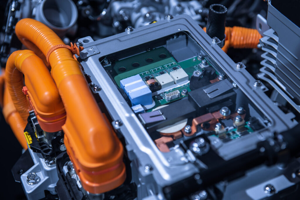 Chassis of the electric car with powertrain and power connections closeup. Blue toned. EV car drivetrain at maintenance